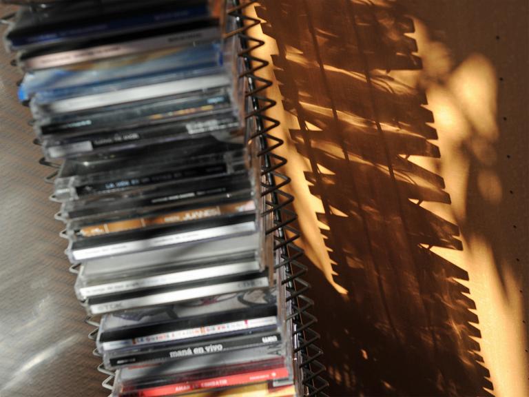 CDs in einem CD-Regal werfen einen Schatten an die Wand.