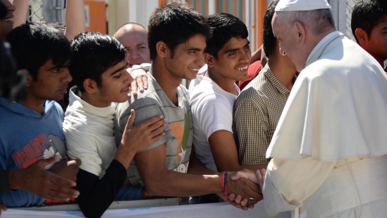 Papst Franziskus schüttelt jungen Flüchtlinge die Hand im Aufnahmezentrum Moria auf Lesbos Papst Franziskus schüttelt jungen Flüchtlinge die Hand im Aufnahmezentrum Moria auf Lesbos