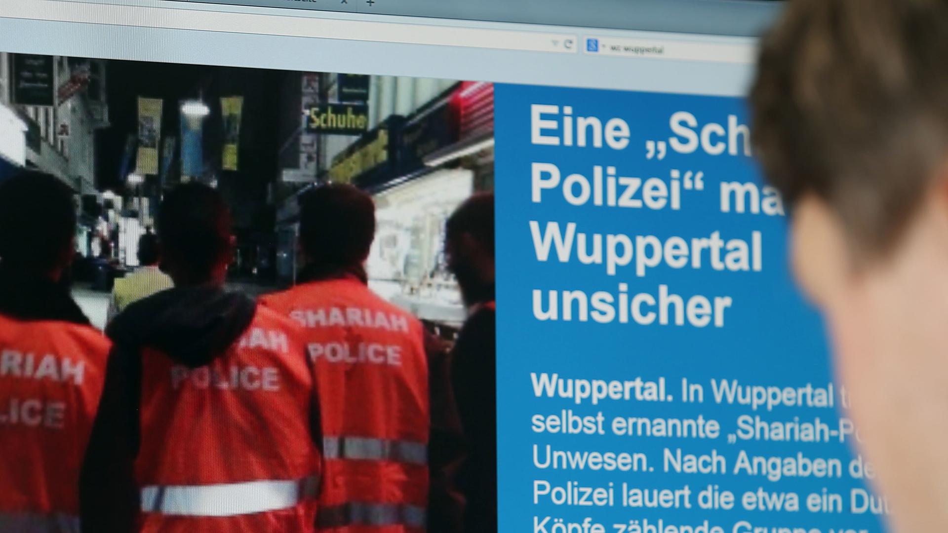 Ein Mann blickt auf einen Computer-Bildschirm, auf dem selbsternannte "Scharia-Polizisten" zu sehen sind. Ein Mann blickt auf einen Computer-Bildschirm, auf dem selbsternannte "Scharia-Polizisten" zu sehen sind.