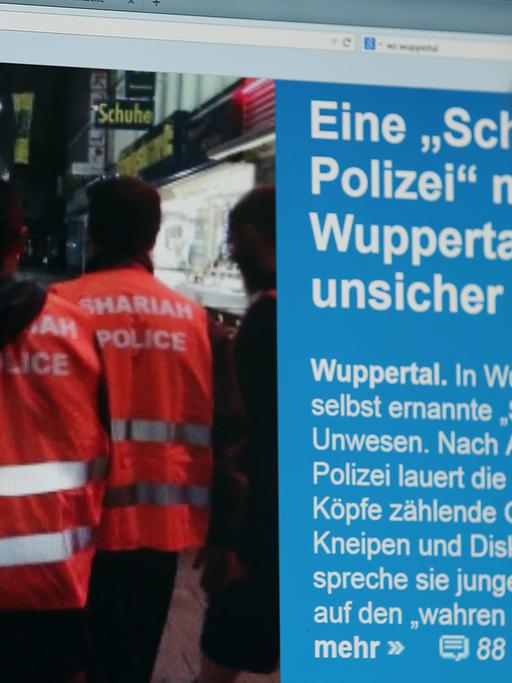 Ein Mann blickt auf einen Computer-Bildschirm, auf dem selbsternannte "Scharia-Polizisten" zu sehen sind.