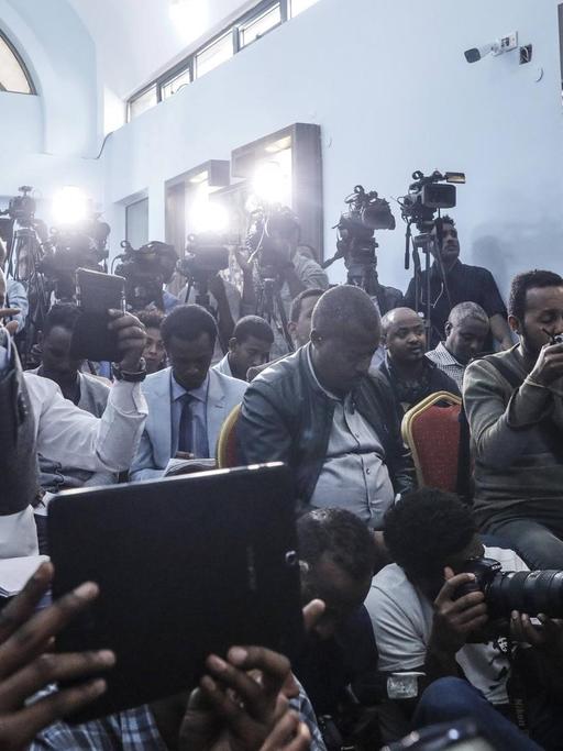 In einem schmalen, langgezogenen Raum eines Regierungsgebäudes in Äthiopiens Hauptstadt Addis Abeba drängen sich etliche Journalisten mit TV- und Fotokameras.