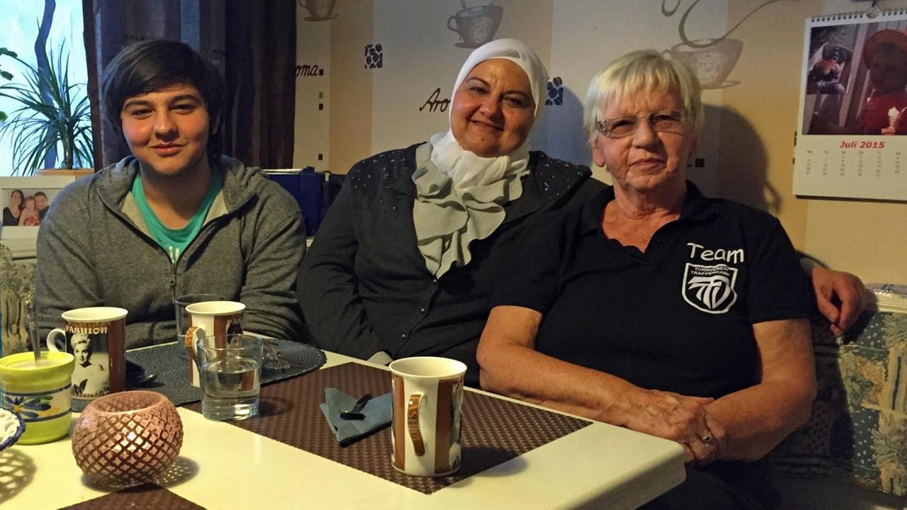 Saad und seine Mutter sitzen gemeinsam mit Edeltraut Söhnel in einer Küche bei Kaffee. Saad und seine Mutter sitzen gemeinsam mit Edeltraut Söhnel in einer Küche bei Kaffee.