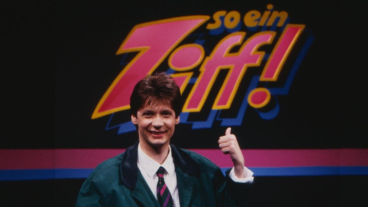 Günther Jauch im Fernsehstudio vor dem Logo der Sendung "So ein Zoff!" (1987) 