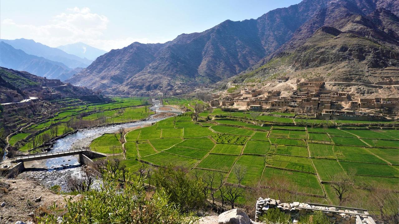 Das Pech-Tal in Kunar. Die Provinz ist nach dem Fluss benannt und ist so fruchtbar, dass sie ganz Afghanistan ernähren könnte. Grüne Felder um den Fluss zwischen hohen Bergen. Das Pech-Tal in Kunar. Die Provinz ist nach dem Fluss benannt und ist so fruchtbar, dass sie ganz Afghanistan ernähren könnte. Grüne Felder um den Fluss zwischen hohen Bergen.
