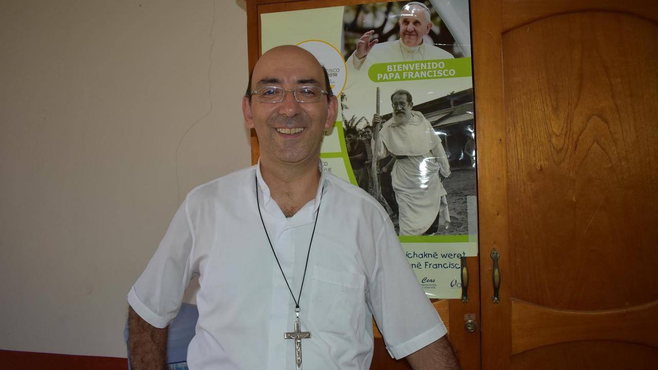Bischof David Martinez vor einem Poster von Papst Franziskus Bischof David Martinez vor einem Poster von Papst Franziskus