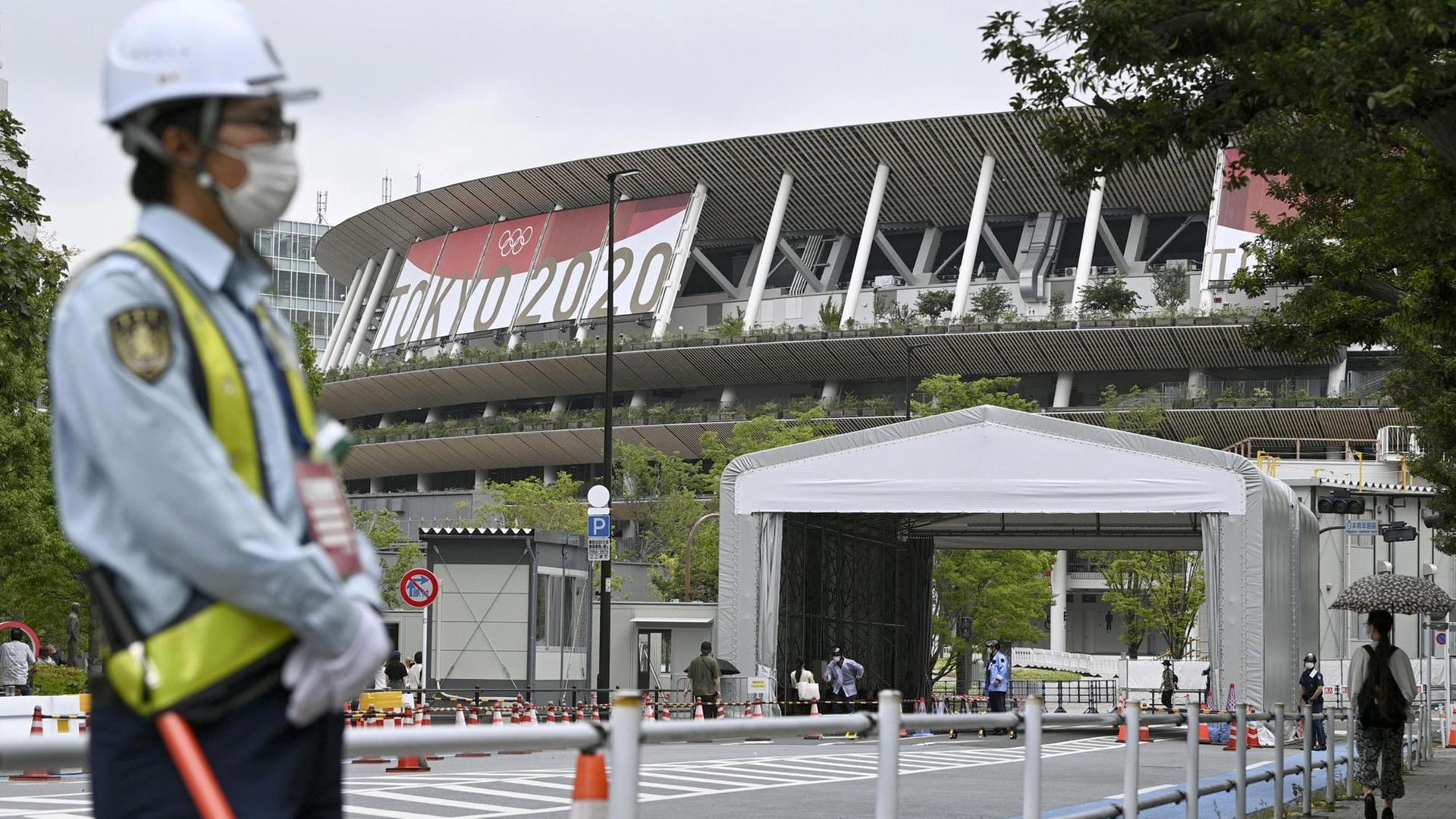 Ein Mann steht vor dem Stadion in Tokio. Ein Mann steht vor dem Stadion in Tokio.