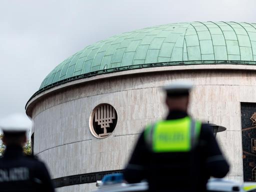 Beamte der Polizei stehen Wache während einer Mahnwache vor der Synagoge der Jüdischen Gemeinde Düsseldorf