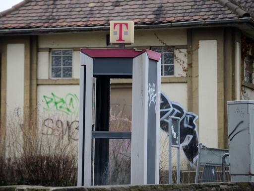 An einer Telefonzelle in Kassel sind Scheiben herausgebrochen. Die Zahl der Telefonzellen hat sich innerhalb weniger Jahre bundesweit mehr als halbiert.