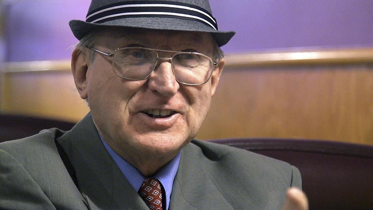 Das Bild zeigt den Kopf von Jones, der Brille und Hut trägt.
Das Bild zeigt den Kopf von Jones, der Brille und Hut trägt.