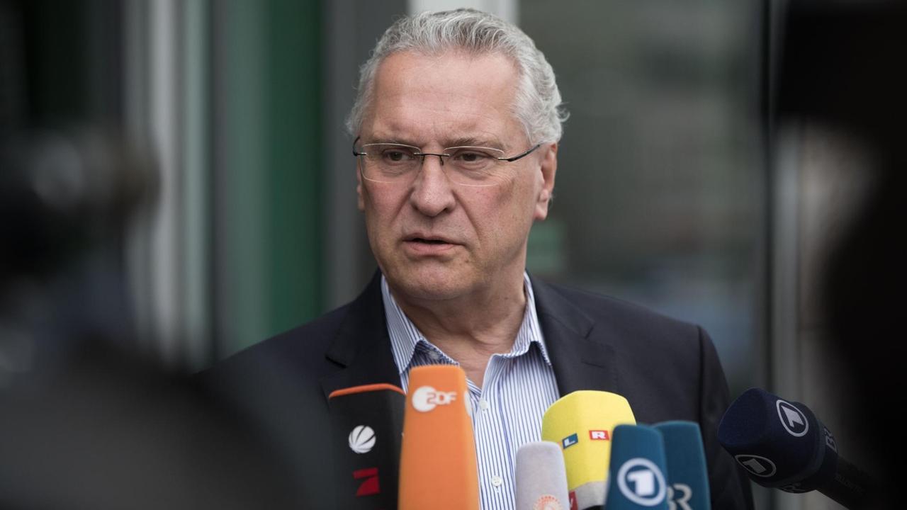 Bayerns Innen- und Verkehrsminister Joachim Herrmann (CSU), vor ihm Mikrofone mehrerer Sender.