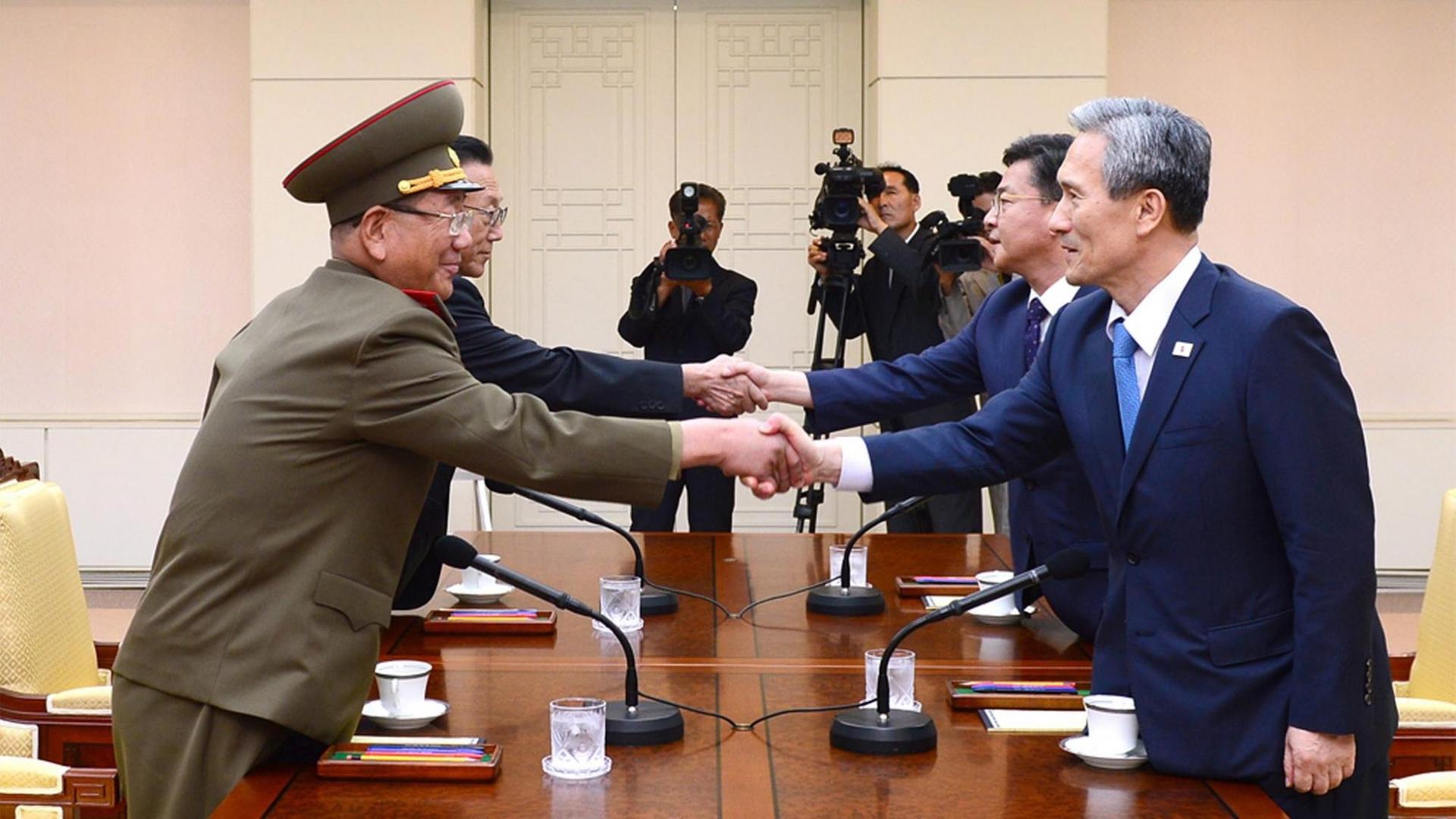 Die Teilnehmer der Regierungsdelegationen von Nord- und Südkorea reichen sich in Panmunjom am 22.08.2015 die Hand