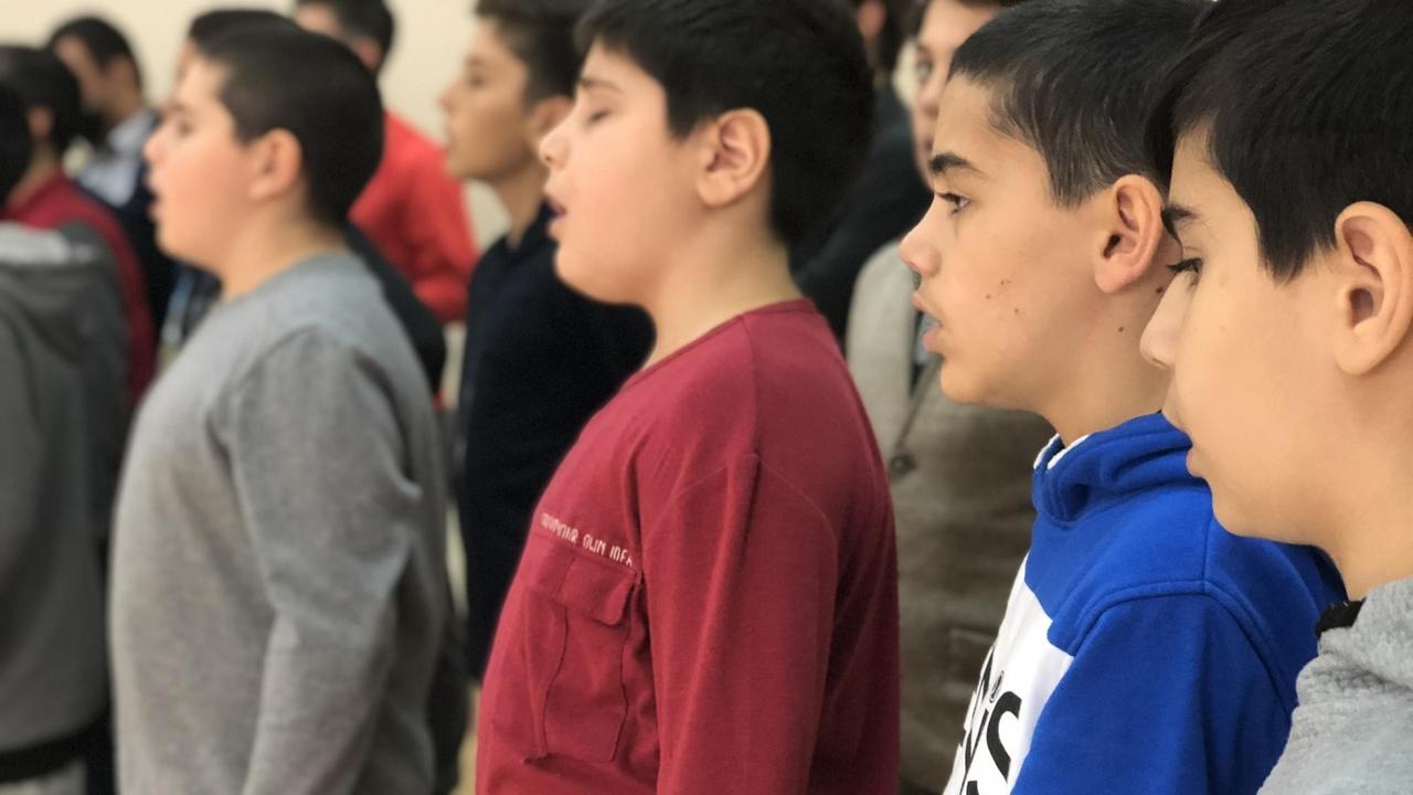 Einige Jungen sind konzentriert und vertieft beim Singen. Einige Jungen sind konzentriert und vertieft beim Singen.