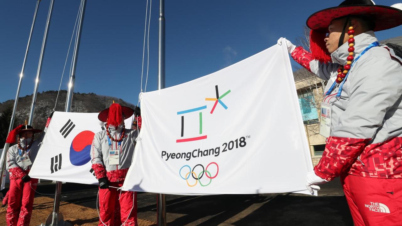 Olympische Spiele Pyeongchang 2018 - Helfer üben das Hissen der südkoreanischen (l) und olympischen Fahne im Olympischen Dorf. Olympische Spiele Pyeongchang 2018 - Helfer üben das Hissen der südkoreanischen (l) und olympischen Fahne im Olympischen Dorf.