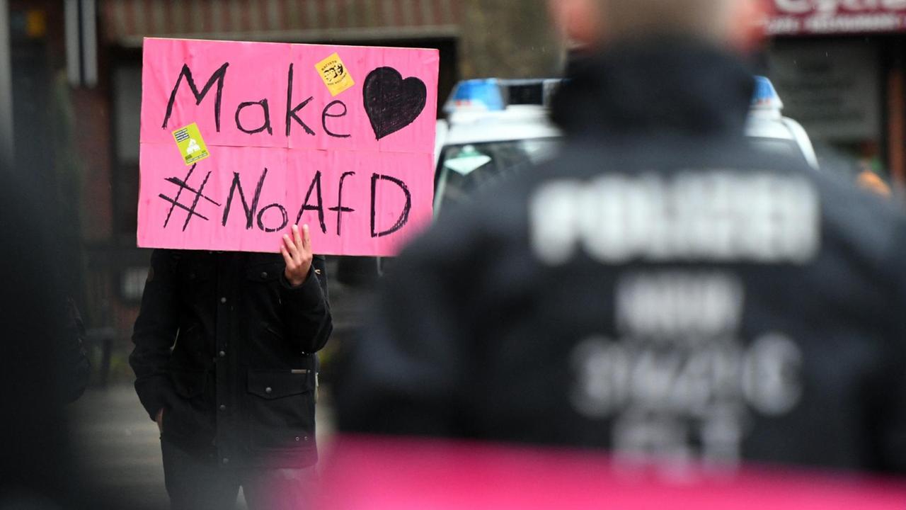 Ein Teinehmer einer Demonstration gegen den Bundesparteitg der AfD hält ein Plakat mit der Aufschrift "Make love, no AfD"