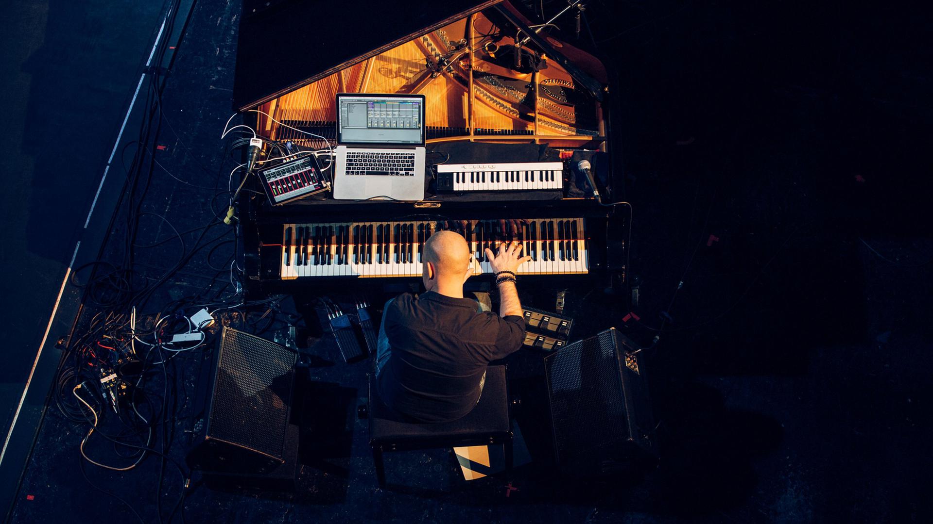 Der schwedische Pianist und Komponist Jakob Karlzon an seinem Arbeitsplatz, dem Flügel, auf dem auch noch Keyboard und Computer stehen. Der schwedische Pianist und Komponist Jakob Karlzon an seinem Arbeitsplatz, dem Flügel, auf dem auch noch Keyboard und Computer stehen.
