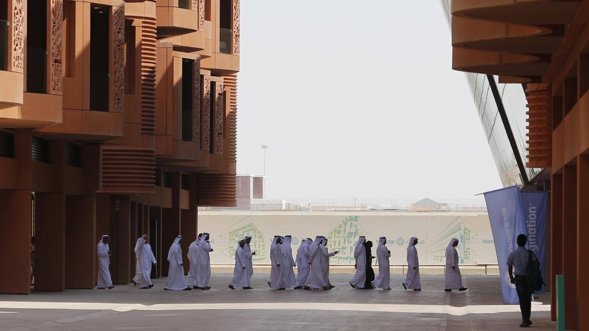 Emiratis walk in Masdar City, on the outskirts of the rich Emirate of Abu Dhabi, on October 7, 2015. Masdar City is a high-density, pedestrian-friendly development where current and future renewable energy and clean technologies are showcased, marketed, researched, developed, tested and implemented. Emiratis walk in Masdar City, on the outskirts of the rich Emirate of Abu Dhabi, on October 7, 2015. Masdar City is a high-density, pedestrian-friendly development where current and future renewable energy and clean technologies are showcased, marketed, researched, developed, tested and implemented.
