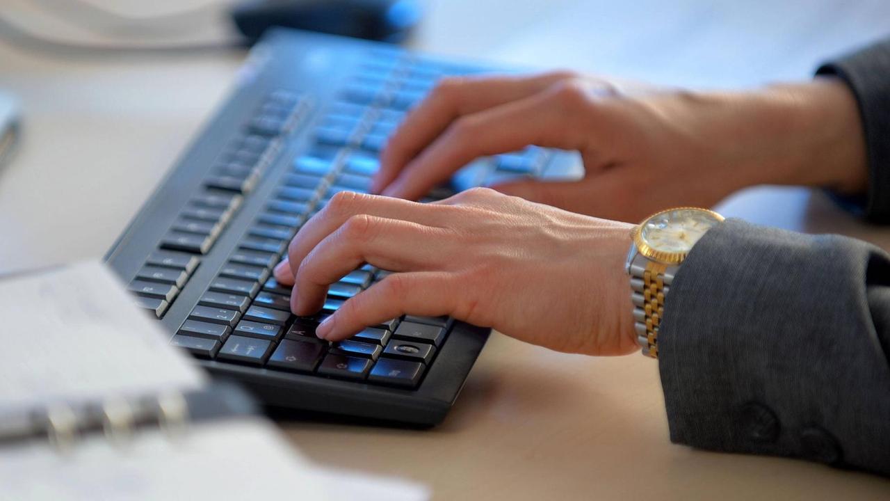 Eine Frau arbeitet an einer Computer-Tastatur. Eine Frau arbeitet an einer Computer-Tastatur.