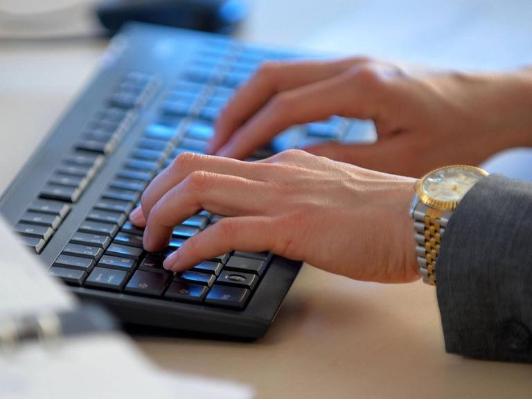 Eine Frau arbeitet an einer Computer-Tastatur.