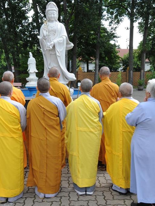 Mönche und Nonnen beten am Mittwoch (08.08.2012) vor einer Avalokiteshvara-Statue, die vor dem buddhistischen Kloster Pagode Vien Giac in Hannover aufgestellt wurde.
