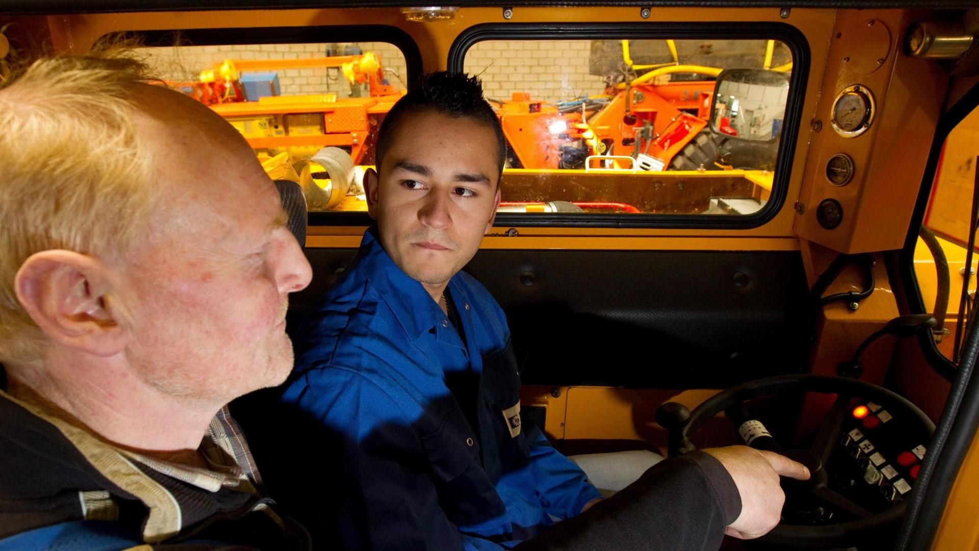 Ausbildungsmeister Karl Schomaker (l) erklärt dem Spanier Daniel Marín Carmona in einer Werkshalle der Firma Hermann Paus Maschinenfabrik GmbH in Emsbüren (Landkreis Emsland) die Funktionen eines Bergfahrzeugs. Im Kampf gegen den Fachkräftemangel startet das Wirtschaftsbündnis Ems-Achse eine internationale Ausbildungsinitiative. Ausbildungsmeister Karl Schomaker (l) erklärt dem Spanier Daniel Marín Carmona in einer Werkshalle der Firma Hermann Paus Maschinenfabrik GmbH in Emsbüren (Landkreis Emsland) die Funktionen eines Bergfahrzeugs. Im Kampf gegen den Fachkräftemangel startet das Wirtschaftsbündnis Ems-Achse eine internationale Ausbildungsinitiative.