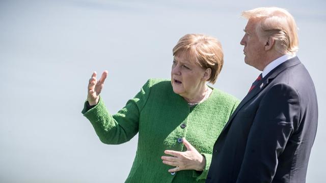 Bundeskanzlerin Angela Merkel (CDU) spricht mit Donald Trump, Präsident der USA, nach dem Familienfoto.