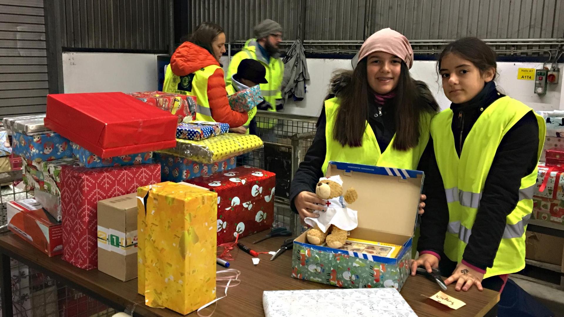 Nele (links) und Alison schauen in Päckchen, denen die Altersangabe fehlt, verpacken sie und schreiben drauf, für wen sich das Geschenk eignet. Nele (links) und Alison schauen in Päckchen, denen die Altersangabe fehlt, verpacken sie und schreiben drauf, für wen sich das Geschenk eignet.