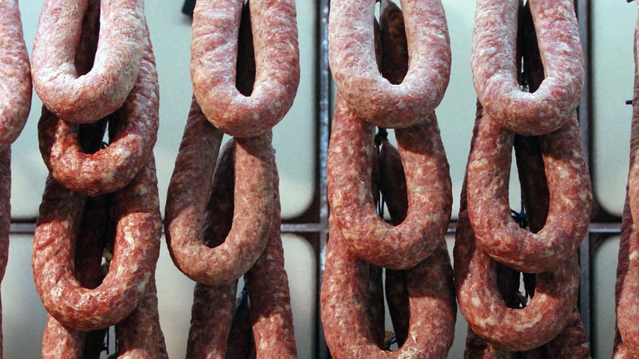 Mehrere "Ahle Würste" im Ring hängen in einer Metzgerei an Haken. Mehrere "Ahle Würste" im Ring hängen in einer Metzgerei an Haken.