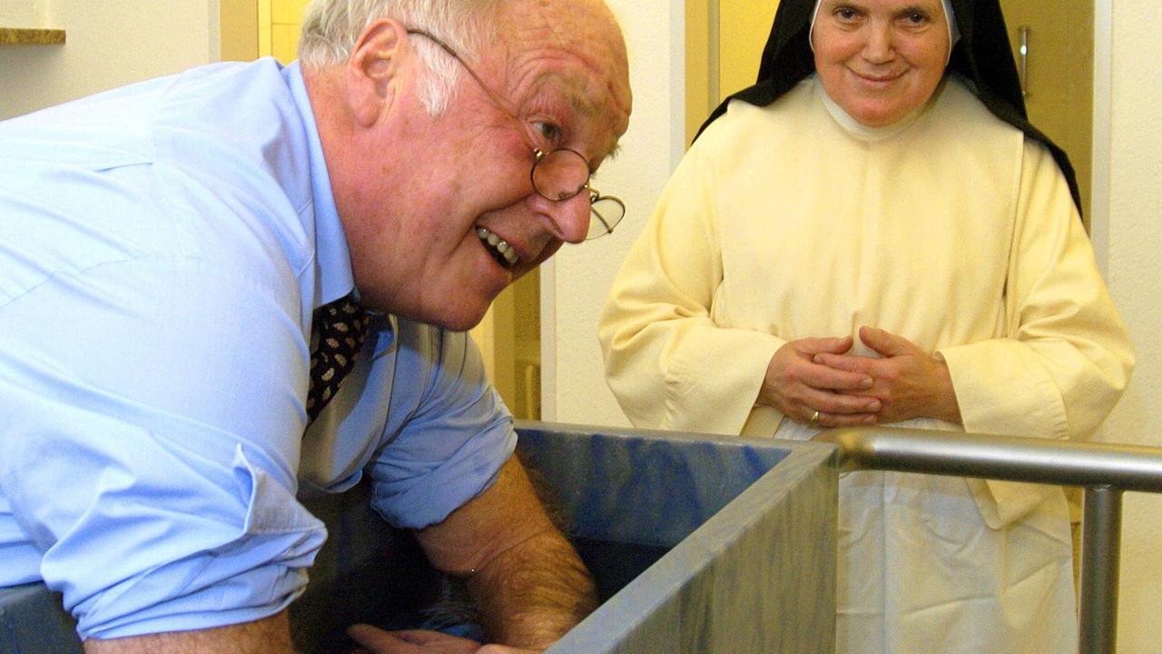 Ein Farbfoto zeigt einen Mann in blauen Hemd mit hochgekrempelten Ärmeln, die Arme in ein längliches Wasserbecken halten im Hintergrund eine Nonne in Ordenstracht
Unter Aufsicht von Schwester Maria Johanna hält der frühere Arbeitsminister Norbert Blüm am Samstag (28.01.2006) in Bad Wörishofen seine Arme in eiskaltes Wasser. Der Politiker machte Anwendungen nach Pfarrer Kneipp. In diesem Kloster entwickelte Sebastian Kneipp im 19. Jahrhundert die nach ihm benannte Therapie. Foto: Stefan Puchner dpa/lby +++(c) dpa - Rep
Der frühere Arbeitsminister Norbert Blüm, 2006 bei einer Kneipp-Anwendug im Kloster Bad Wörishofen, in dem Sebastian Kneipp seine Therapie entwickelte Ein Farbfoto zeigt einen Mann in blauen Hemd mit hochgekrempelten Ärmeln, die Arme in ein längliches Wasserbecken halten im Hintergrund eine Nonne in Ordenstracht
Unter Aufsicht von Schwester Maria Johanna hält der frühere Arbeitsminister Norbert Blüm am Samstag (28.01.2006) in Bad Wörishofen seine Arme in eiskaltes Wasser. Der Politiker machte Anwendungen nach Pfarrer Kneipp. In diesem Kloster entwickelte Sebastian Kneipp im 19. Jahrhundert die nach ihm benannte Therapie. Foto: Stefan Puchner dpa/lby +++(c) dpa - Rep
Der frühere Arbeitsminister Norbert Blüm, 2006 bei einer Kneipp-Anwendug im Kloster Bad Wörishofen, in dem Sebastian Kneipp seine Therapie entwickelte