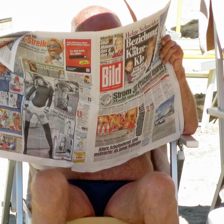 Ein deutscher Urlauber liest die "Bild"-Zeitung am Strand von Grado an der Adria
