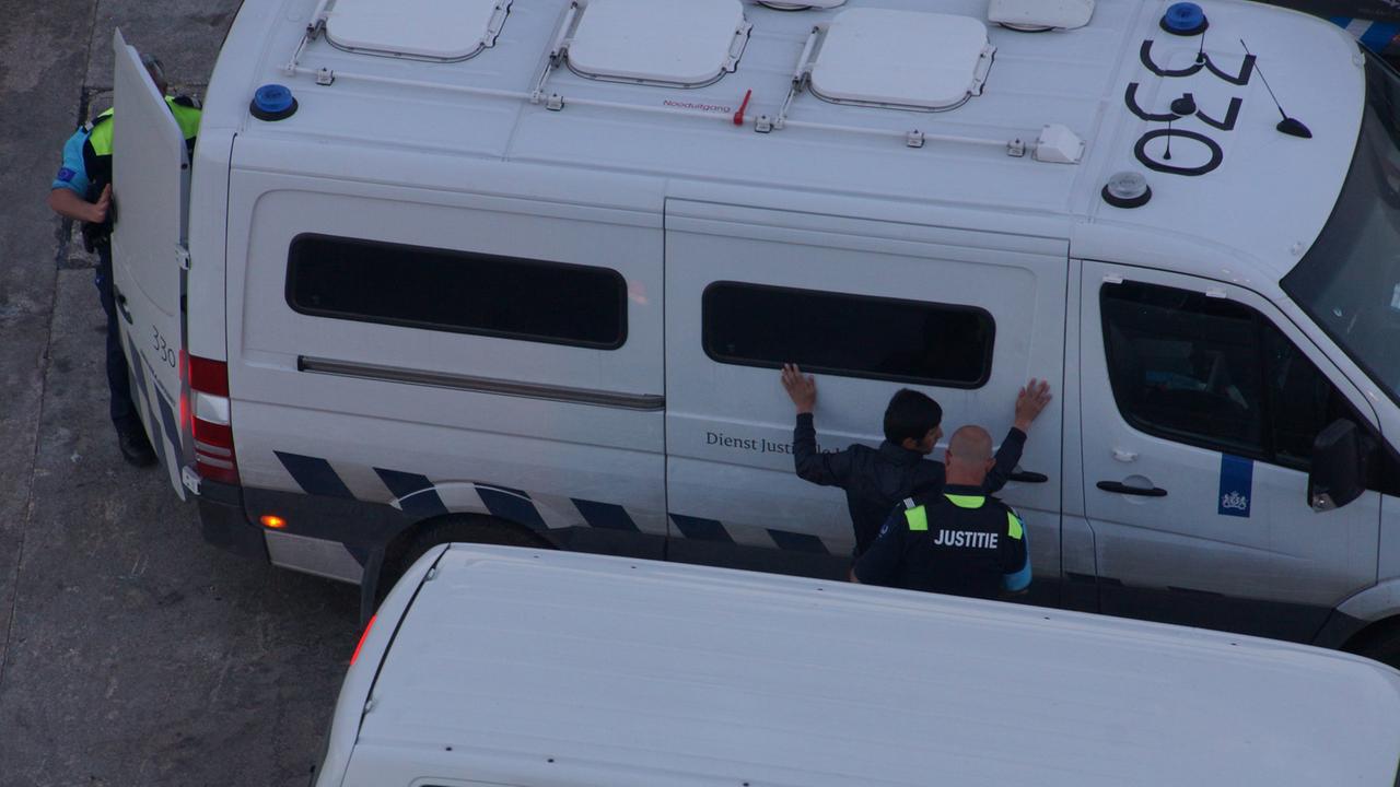 Frontex-Mitarbeiter nehmen einen Flüchtling fest. Frontex-Mitarbeiter nehmen einen Flüchtling fest.