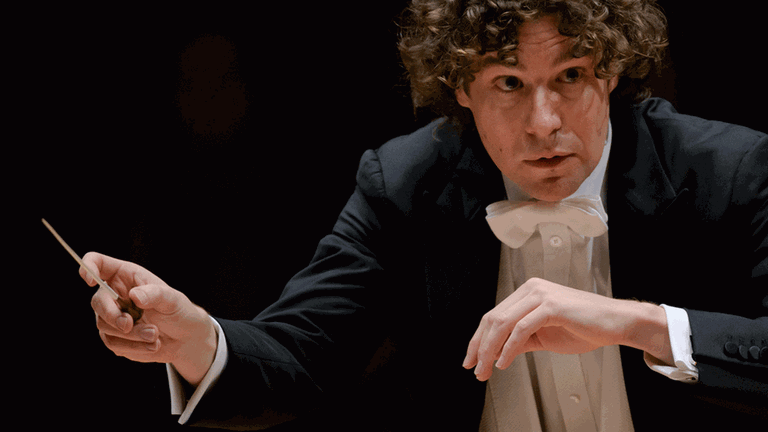 Der Dirigent bei einem konzentrierten Wink zu Musikern im Orchester. Der Dirigent bei einem konzentrierten Wink zu Musikern im Orchester.