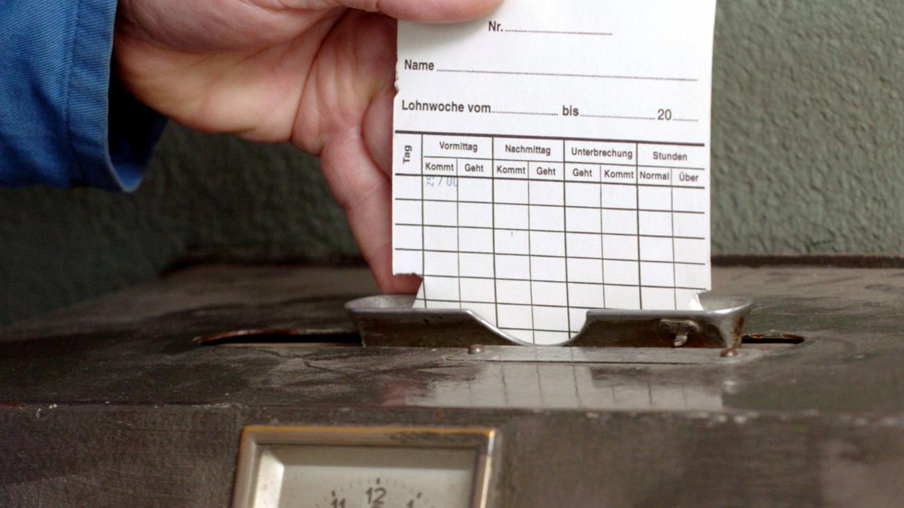 Eine Hand steckt Montag (29.03.2004) in einem Krefelder Unternehmen eine Karte in ein Arbeitszeiterfassungsgerät. Eine Hand steckt Montag (29.03.2004) in einem Krefelder Unternehmen eine Karte in ein Arbeitszeiterfassungsgerät.