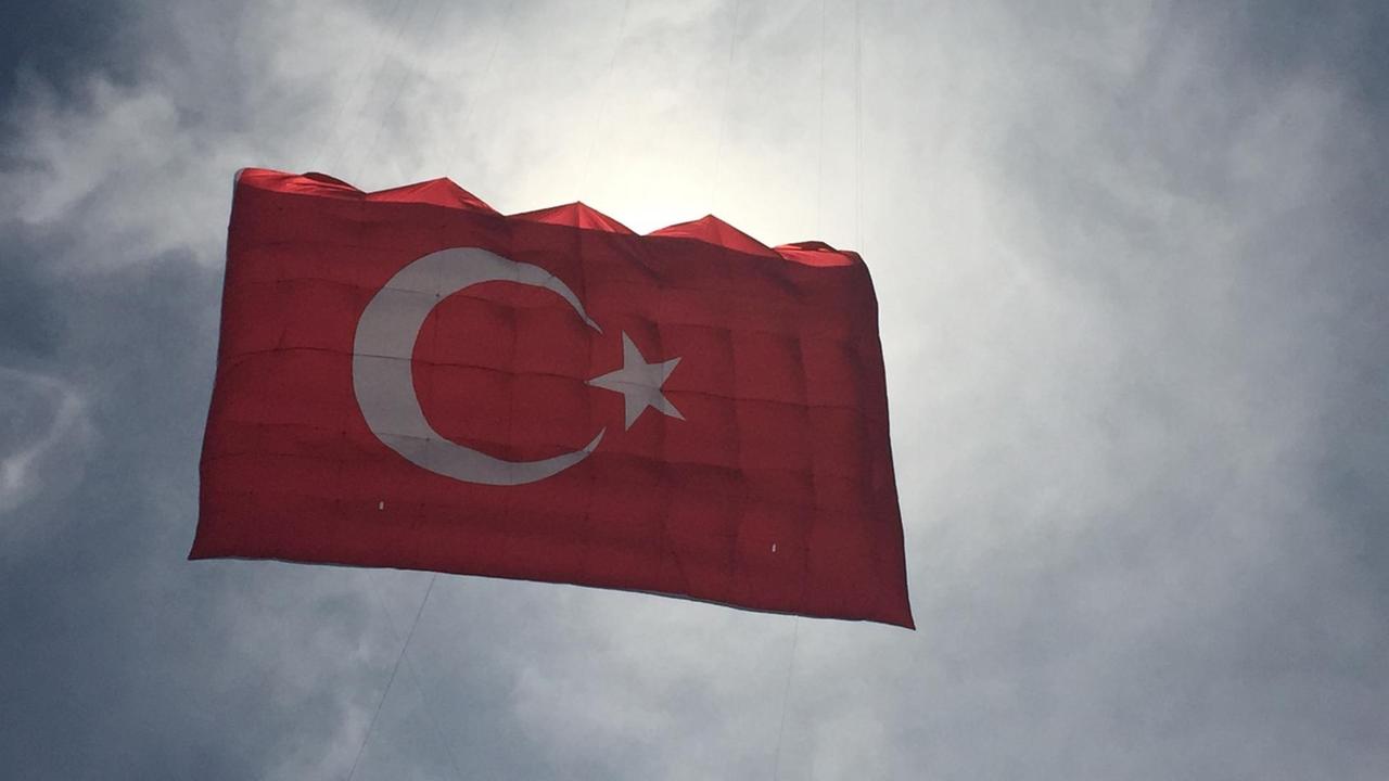 Eine türkische Flagge schwebt durch die Luft. Eine türkische Flagge schwebt durch die Luft.
