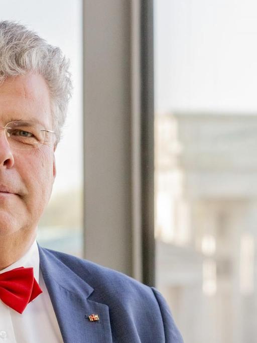 Christian Höppner, Generalsekretär des Deutschen Musikrates und ehemals Präsident des Deutschen Kulturrates, in der Akademie der Künste mit dem Brandenburger Tor im Hintergrund.