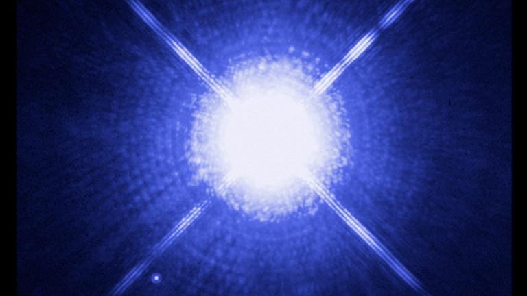 Sirius B, der lichtschwache Begleiter links unterhalb des überstrahlten Sirius A, aufgenommen mit dem Hubble-Weltraumteleskop Sirius B, der lichtschwache Begleiter links unterhalb des überstrahlten Sirius A, aufgenommen mit dem Hubble-Weltraumteleskop