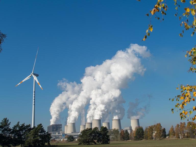 Braunkohlekraftwerk in Jänschwalde neben einem Windkraftrad
