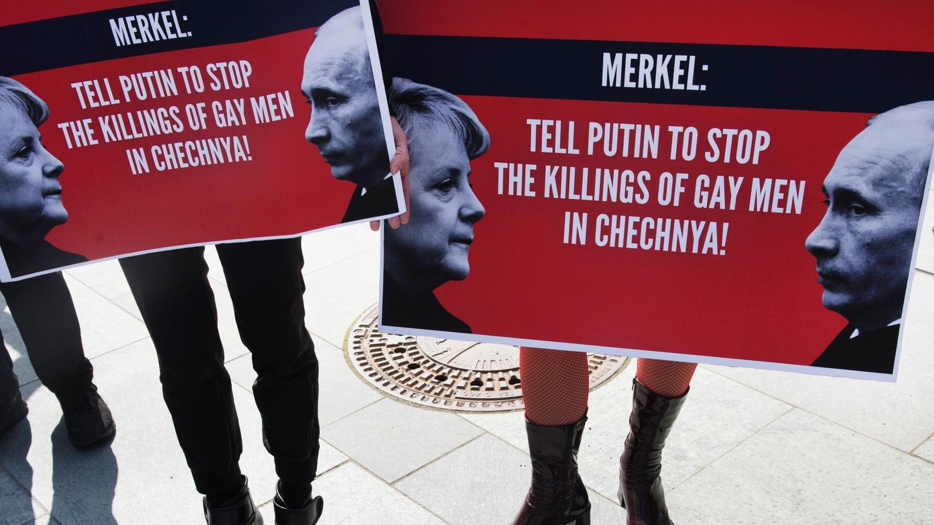 Demonstranten halten am 30.04.2017 in Berlin beim Start einer dreitägigen Mahnwache zum Schutz von Schwulen in Tschetschenien Plakate mit der Aufschrift "Merkel: Tell Putin to Stop the Killings of Gay Men in Chechnya" in den Händen.