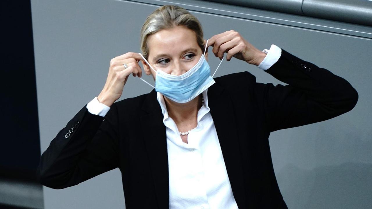 Berlin: Alice Weidel, Fraktionsvorsitzende der AfD, setzt sich nach ihrer Rede während der Generaldebatte zum Bundeshaushalt im Bundestag die Mund-Nasen-Bedeckung auf. Berlin: Alice Weidel, Fraktionsvorsitzende der AfD, setzt sich nach ihrer Rede während der Generaldebatte zum Bundeshaushalt im Bundestag die Mund-Nasen-Bedeckung auf.