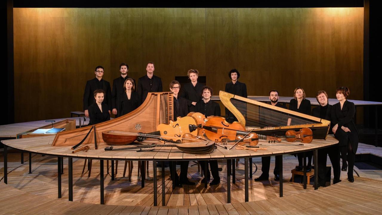Musiker stehen hinter halbrund aufgestellten Tischen, auf denen ihre alten Instrumente präsentiert sind. Musiker stehen hinter halbrund aufgestellten Tischen, auf denen ihre alten Instrumente präsentiert sind.