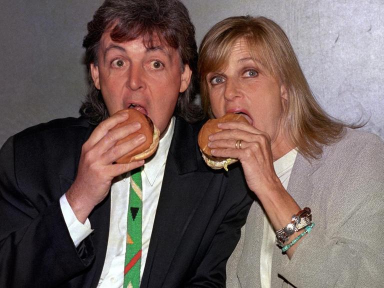 Paul und Linda McCartney posieren für ein Pressefoto und beißen herzhaft in einen vegetarischen Burger.