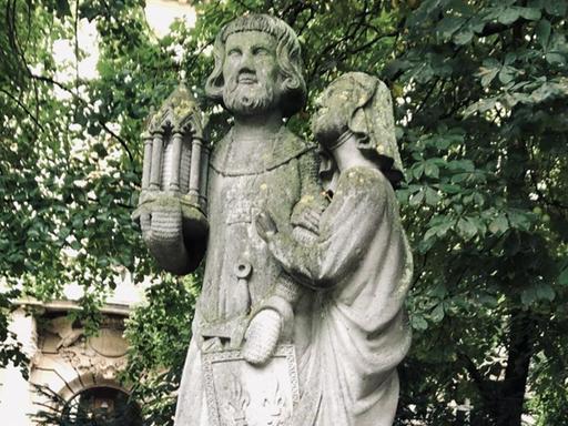 Der französische König Ludwig IX. und seine Gattin Margarete: in Stein gehauene Figuren, in den Gesichtern und auf den Schultern mit Moos überwachsen