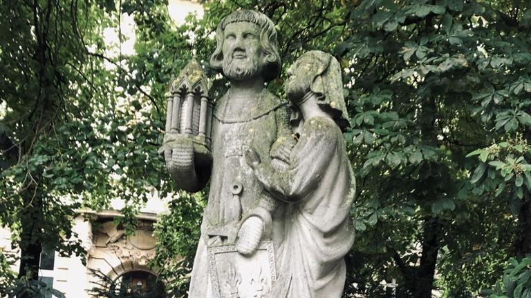 Der französische König Ludwig IX. und seine Gattin Margarete: in Stein gehauene Figuren, in den Gesichtern und auf den Schultern mit Moos überwachsen Der französische König Ludwig IX. und seine Gattin Margarete: in Stein gehauene Figuren, in den Gesichtern und auf den Schultern mit Moos überwachsen