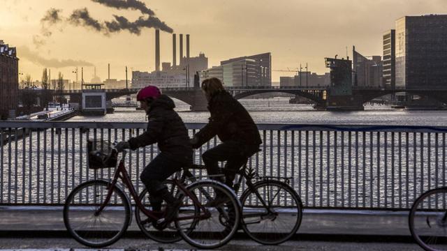 Zwei Fahrradfahrer überqueren eine Brücke über den Südhafenkanal am Innenhafen von Kopenhagen. 