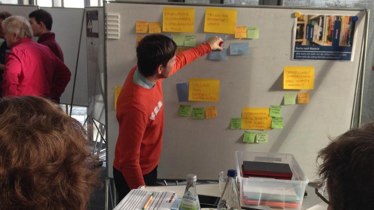 EIn Schüler klebt ein Post-it an eine Stellwand beim Workshop zur Schul-Cloud in Potsdam EIn Schüler klebt ein Post-it an eine Stellwand beim Workshop zur Schul-Cloud in Potsdam