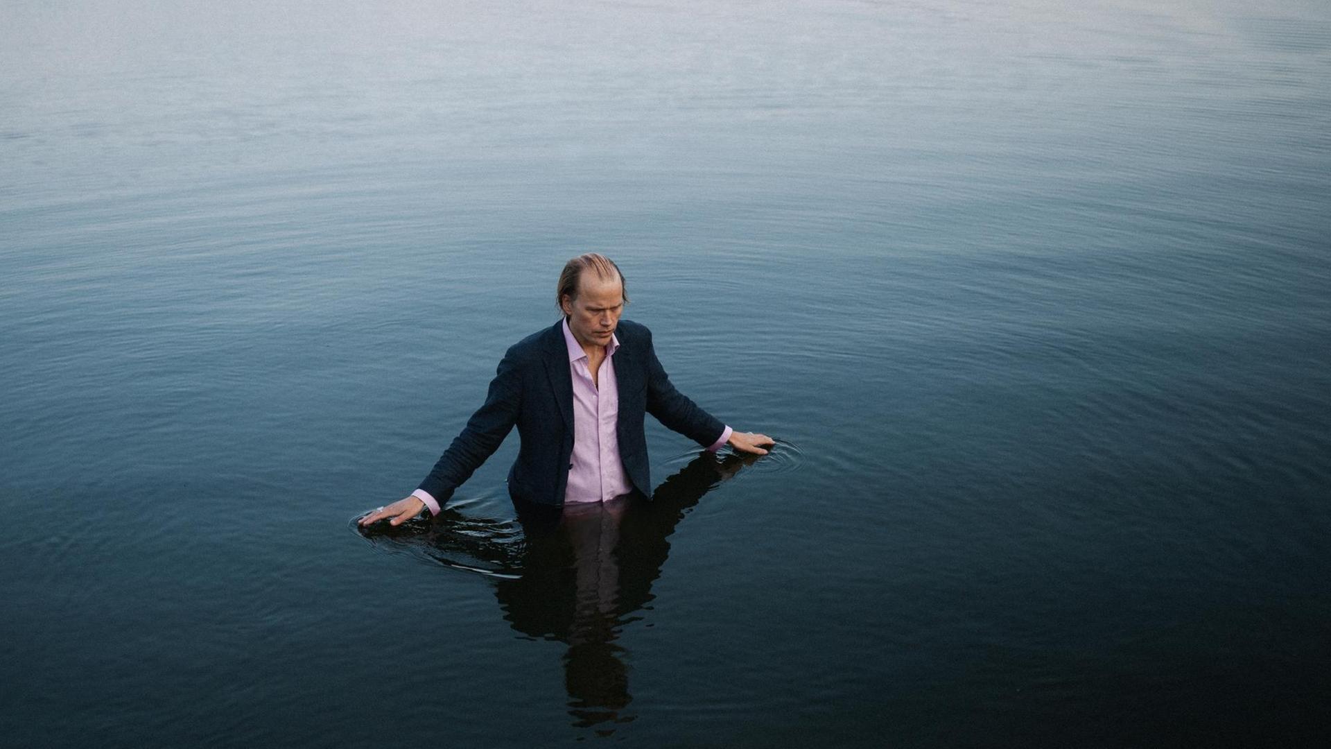 Christian Kjellvander steht bis zur Hüfte im Wasser. Christian Kjellvander steht bis zur Hüfte im Wasser.