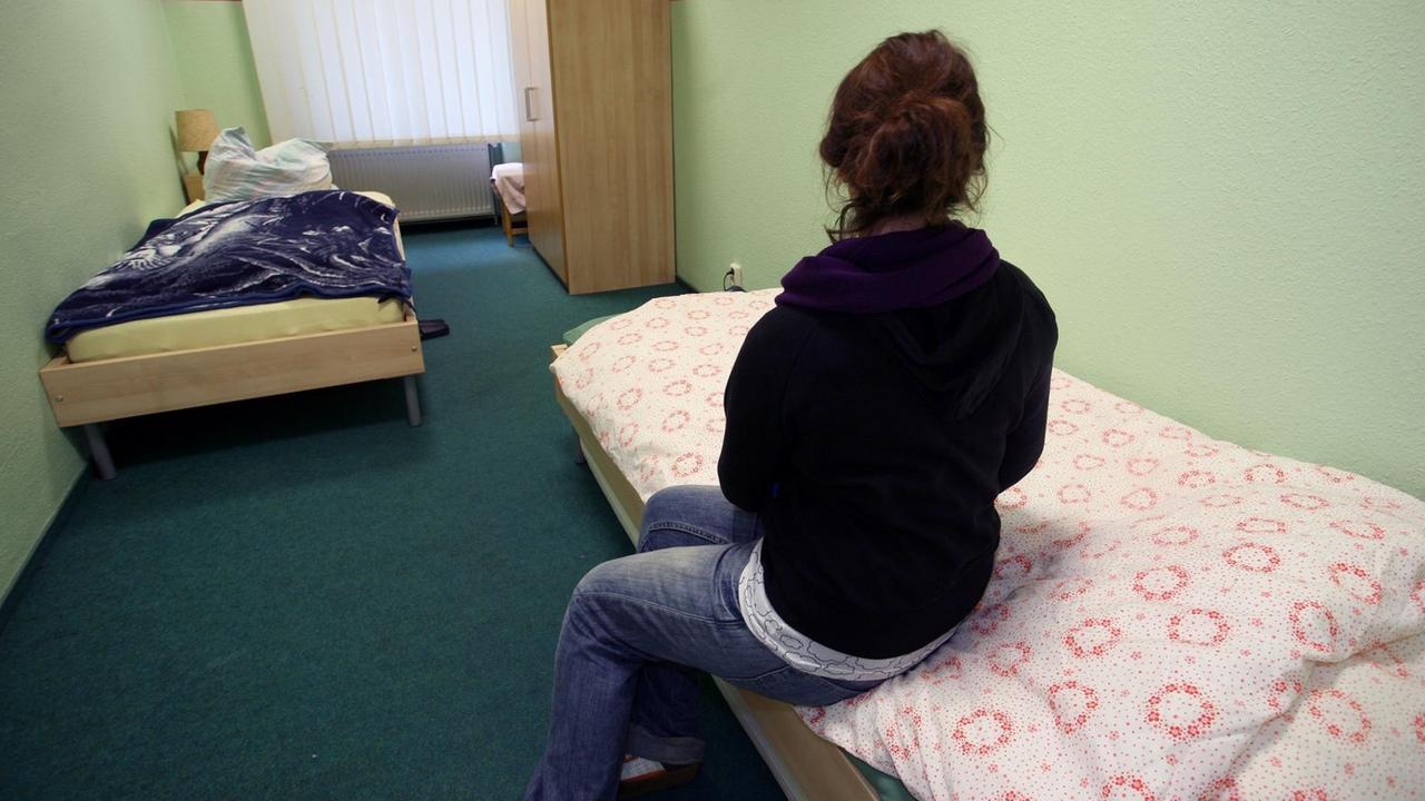 Eine Frau sitzt in einem Zimmer der "Notübernachtung für Frauen" am Donnerstag (11.12.2008) in Berlin beim Tag der offenen Tür auf ihrem Bett. Eine Frau sitzt in einem Zimmer der "Notübernachtung für Frauen" am Donnerstag (11.12.2008) in Berlin beim Tag der offenen Tür auf ihrem Bett.