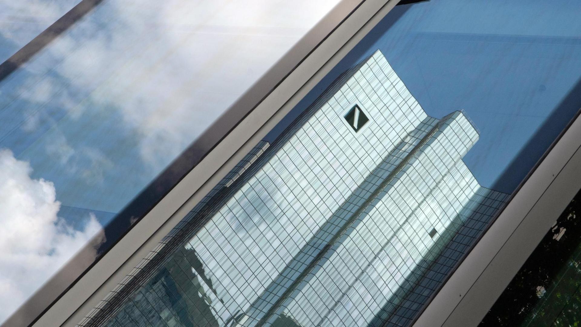 Die Zentrale der Deutschen Bank spiegelt sich in einer Glasfassade. Die Zentrale der Deutschen Bank spiegelt sich in einer Glasfassade.