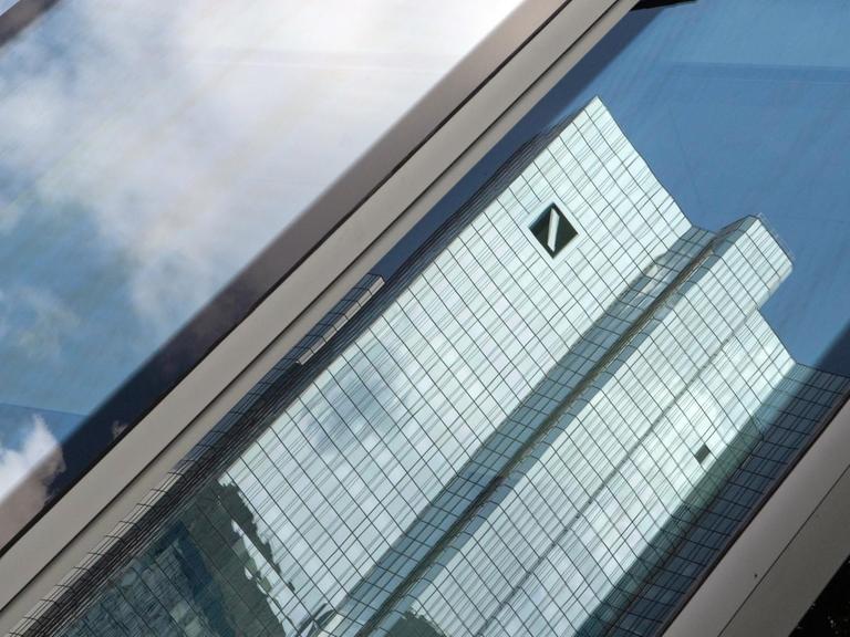 Die Zentrale der Deutschen Bank spiegelt sich in einer Glasfassade.