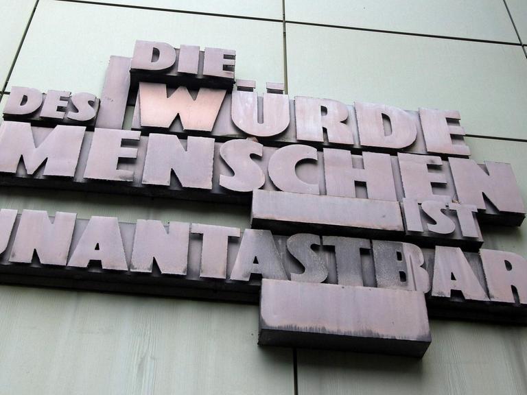 Skulptur mit Artikel 1 des deutschen Grundgesetzes "Die Würde des Menschen ist unantastbar" an der Fassade der Staatsanwaltschaft im Justizzentrum in der Innenstadt Frankfurt.