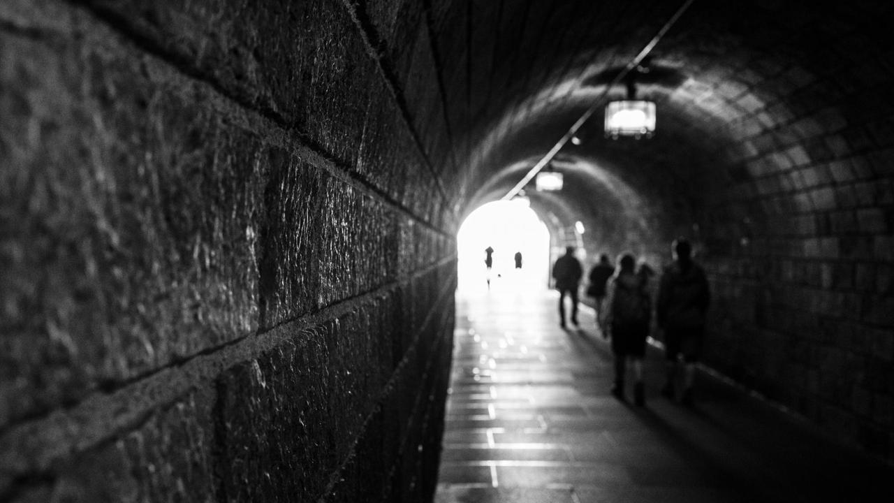 Menschen in einem dunklen Tunnel